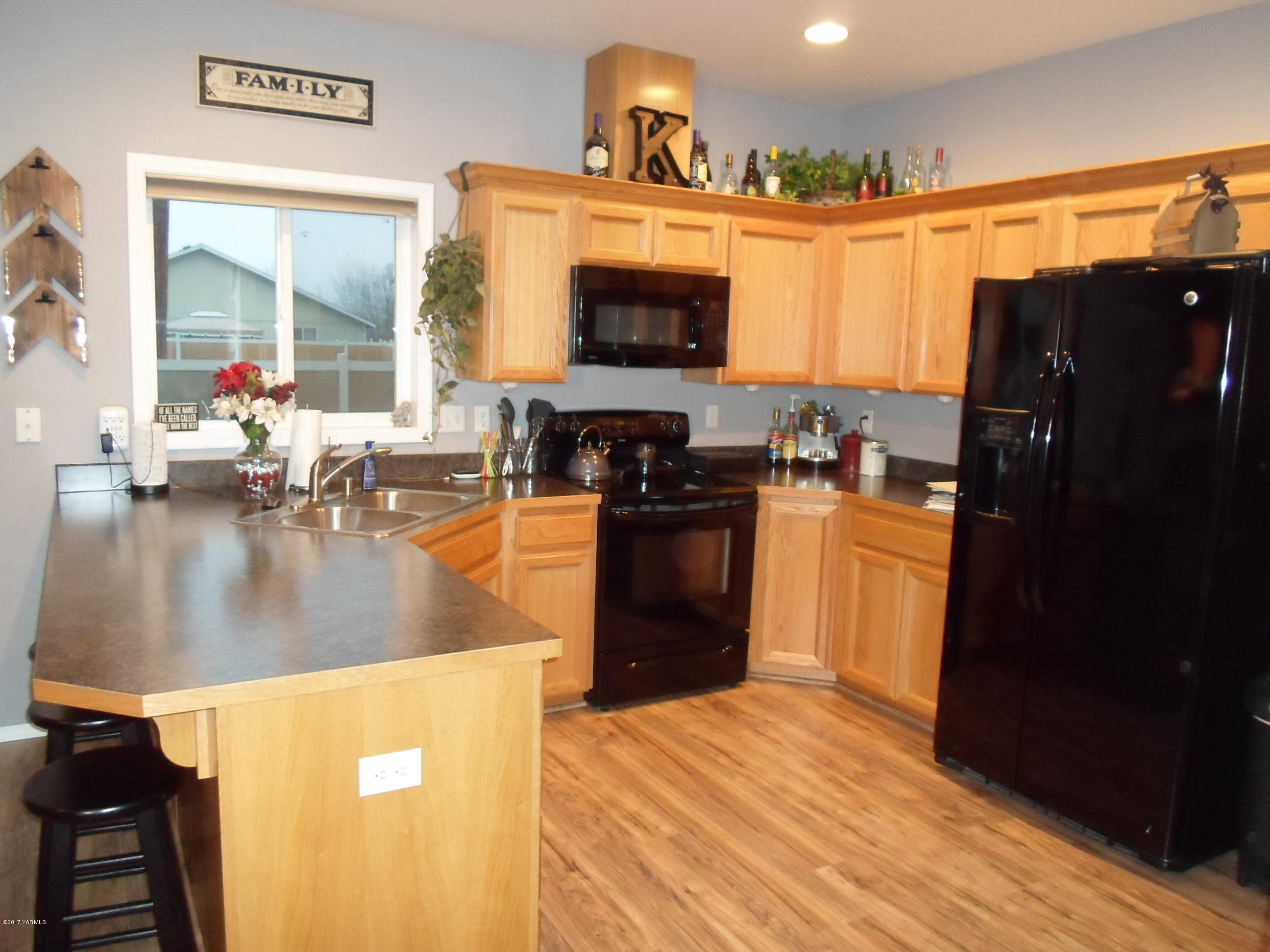 206 South Zeus Street Moxee, WA 98936 - Photo 4 of 22 a kitchen with stainless steel appliances granite countertop a refrigerator a stove and a sink with wooden floor