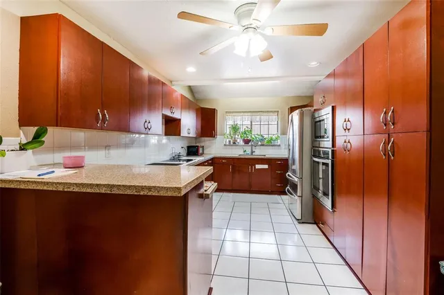 a kitchen with granite countertop stainless steel appliances a counter top space and cabinets