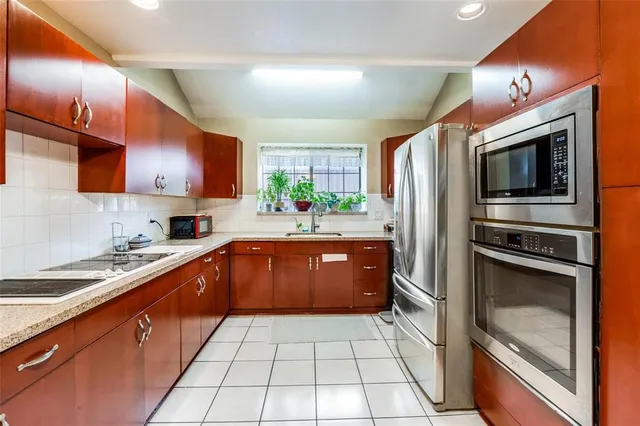 a kitchen with stainless steel appliances granite countertop a sink a stove top oven a counter space and cabinets