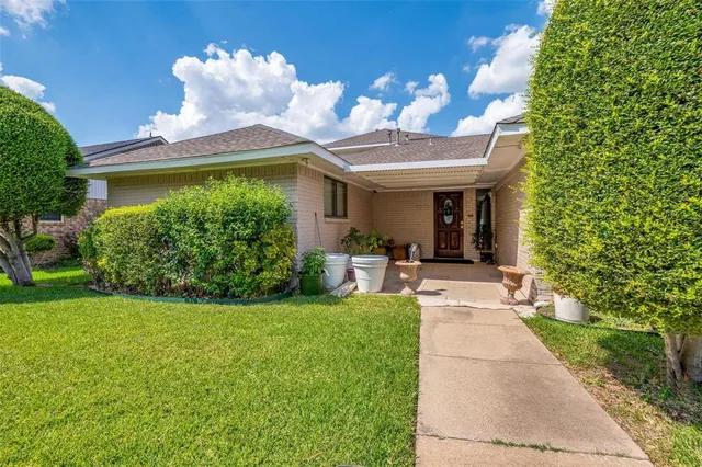 a view of a house with a yard and potted plants