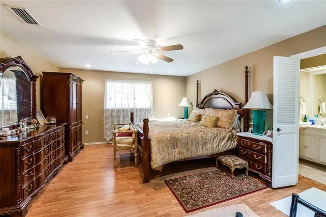 a bedroom with a bed a large window and dresser