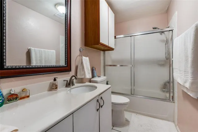 a bathroom with a sink toilet double vanity and shower