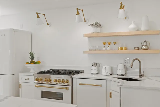 a large white kitchen with a stove top oven