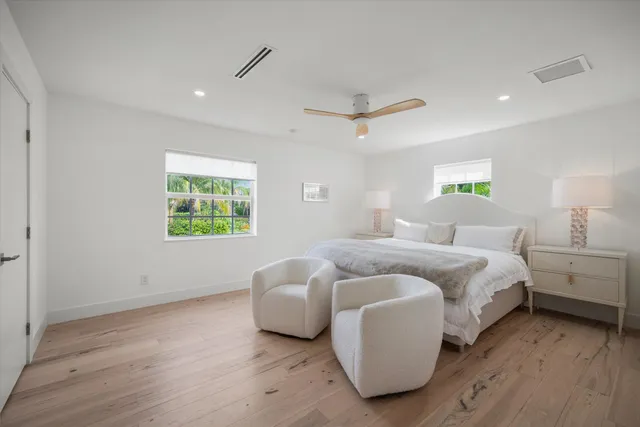 a bathroom with a granite countertop sink vanity mirror and toilet