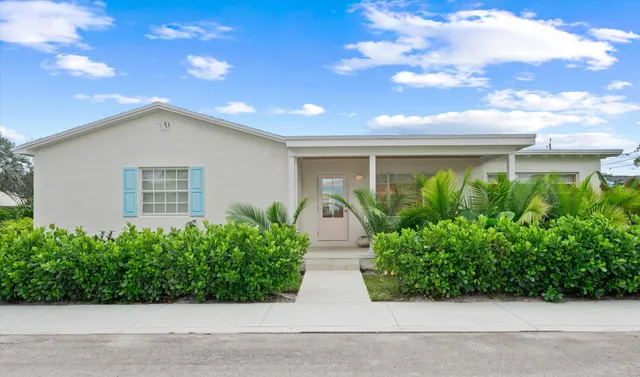 a front view of a house with plants and garage