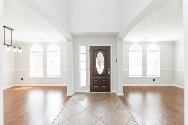an empty room with wooden floor and window