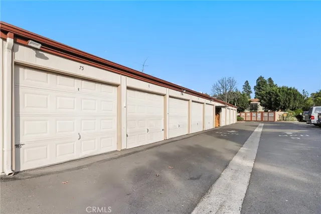 a view of a patio with couches table and chairs under an umbrella with palm trees