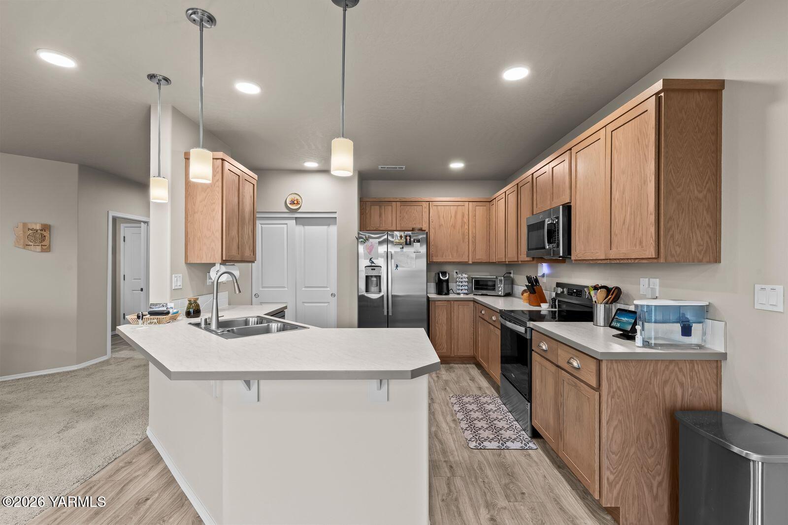 403 Lambert Court Grandview, WA 98930 - Photo 9 of 27 a kitchen with stainless steel appliances kitchen island granite countertop a sink a stove and a refrigerator