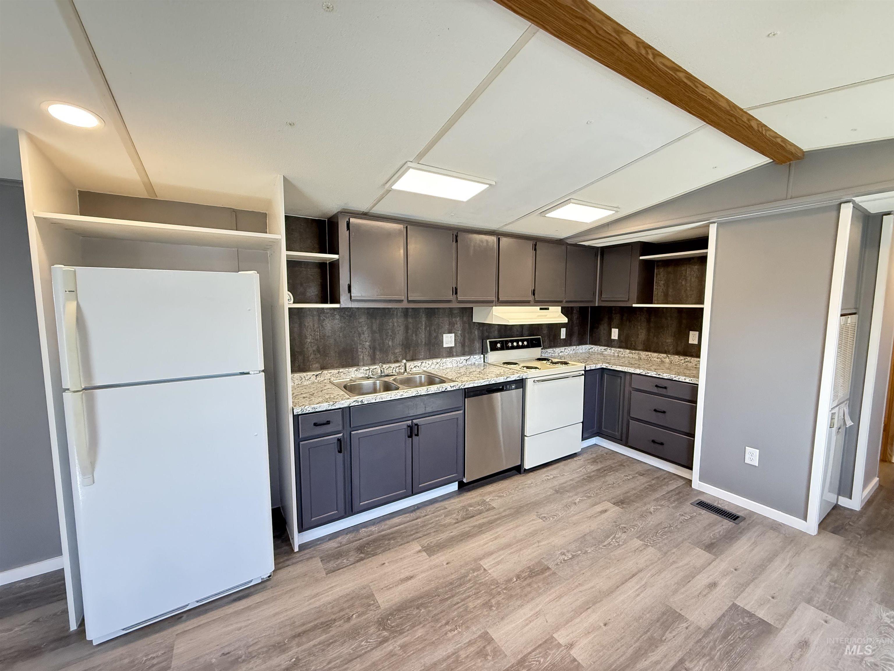 2015 6th Avenue, Unit 321 Clarkston, WA 99403 - Photo 10 of 34 Kitchen featuring open shelves, white appliances, backsplash, light wood-style floors, and vaulted ceiling