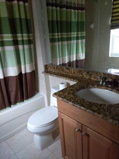 841 Northwest 82nd Lane Boca Raton, FL 33487 - Photo 7 of 9 a bathroom with a granite countertop sink a toilet and tub
