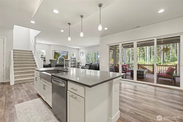 a kitchen with stainless steel appliances granite countertop a sink a stove and a wooden floors