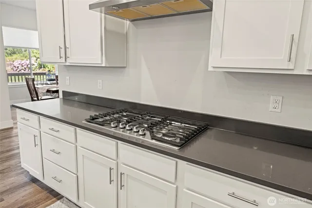 a kitchen with granite countertop a refrigerator sink and cabinets