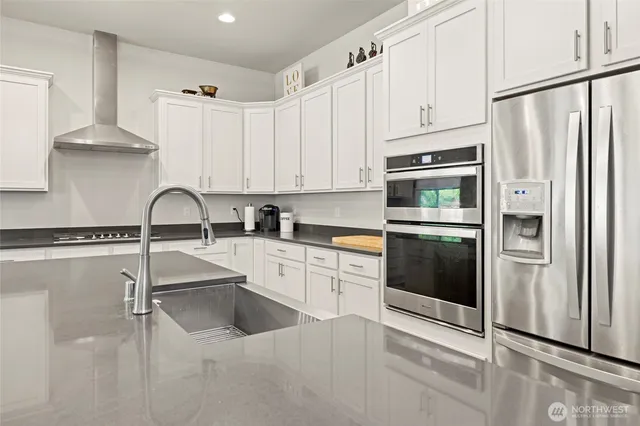 a kitchen with cabinets chairs and wooden floor
