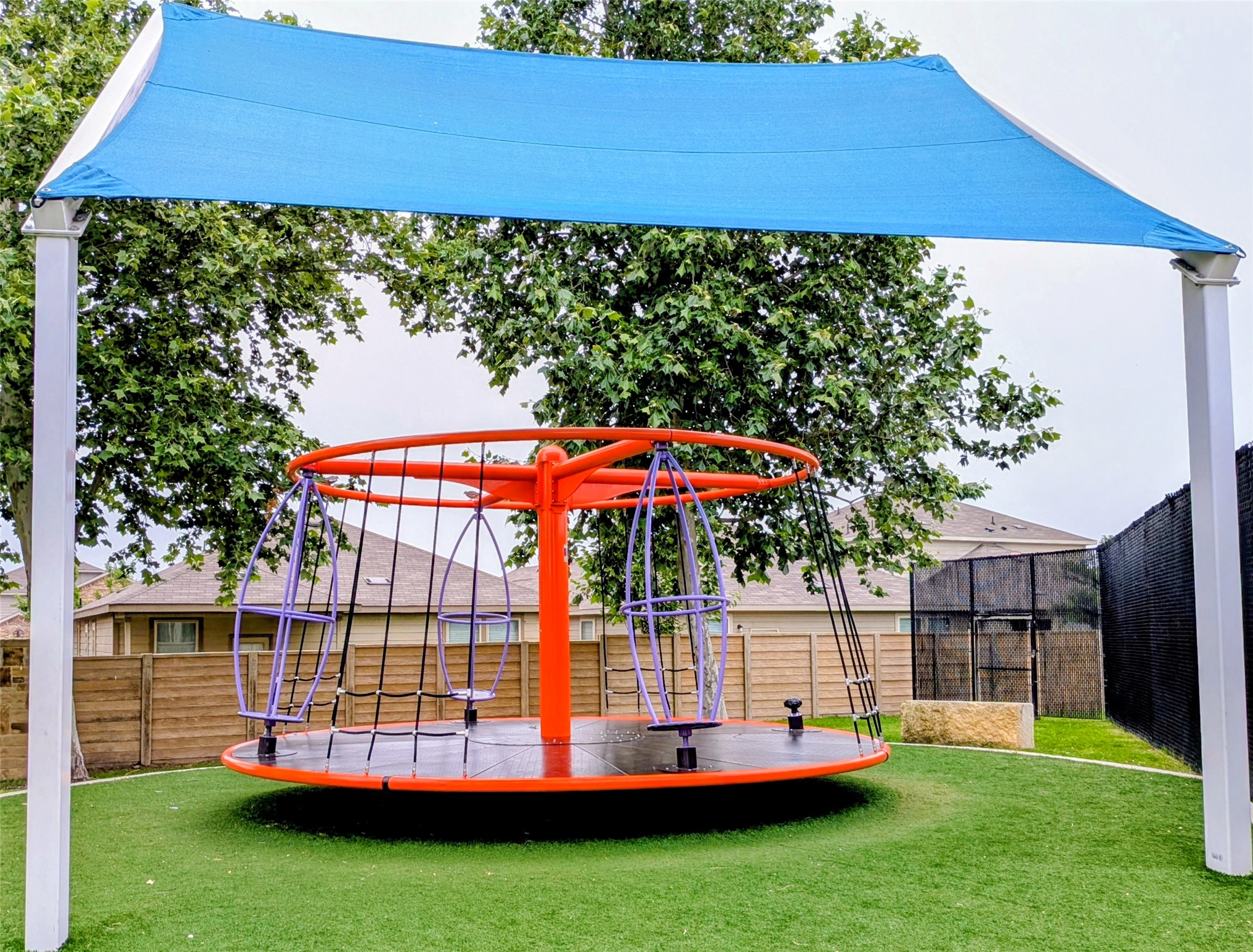 212 Foster Lane Jarrell, TX 76537 - Photo 24 of 26 A vibrant carousel shaded by a blue canopy creates a playful outdoor setting.