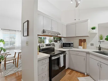 a kitchen with cabinets appliances a sink and a counter top space