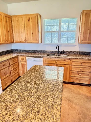 a bathroom with a granite countertop sink a toilet and mirror