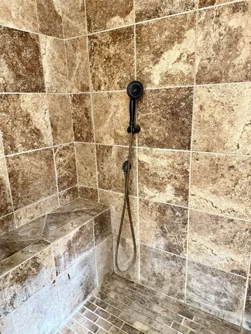 a bathroom with a granite countertop tub sink and mirror