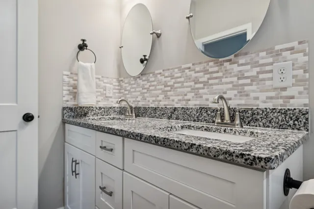 a bathroom with a granite countertop sink and a mirror