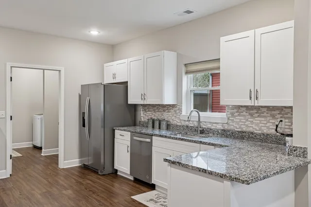 a kitchen with stainless steel appliances granite countertop a sink stove and refrigerator