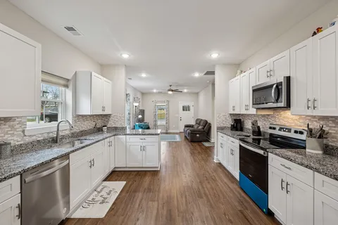 a large kitchen with a lot of counter space and wooden floor
