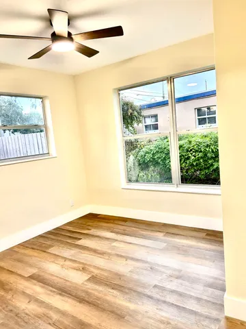 a view of a big room with wooden floor and a ceiling fan