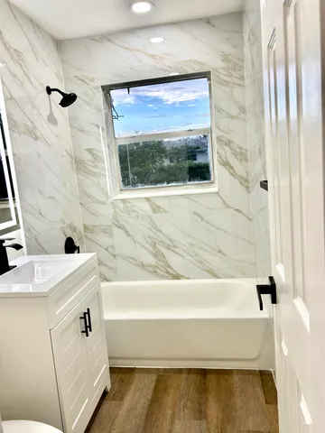 a bathroom with a tub sink and mirror