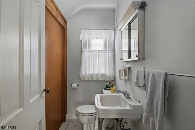 a bathroom with a sink a toilet and a window