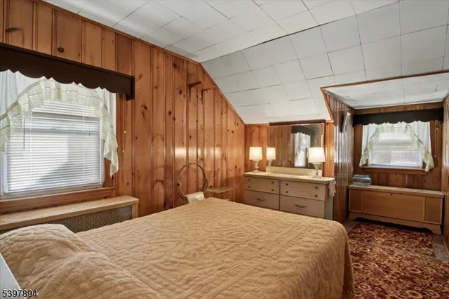 a bedroom with a bed and dresser with mirror