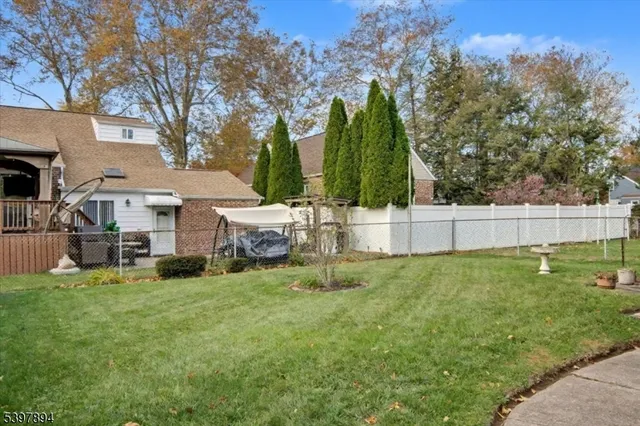 a view of a house with backyard and trees