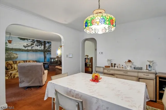 a dining room with kitchen island a chandelier and living room view
