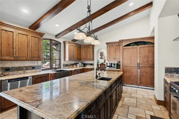 a kitchen with stainless steel appliances granite countertop a sink a stove and a refrigerator