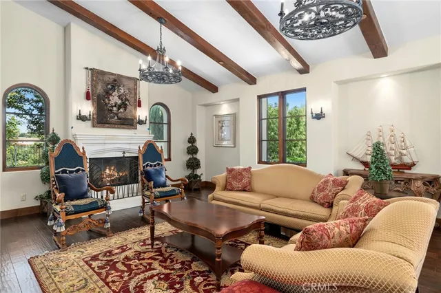 a living room with furniture a fireplace and a chandelier