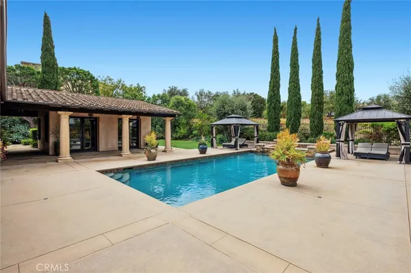 swimming pool view with a seating space and a garden