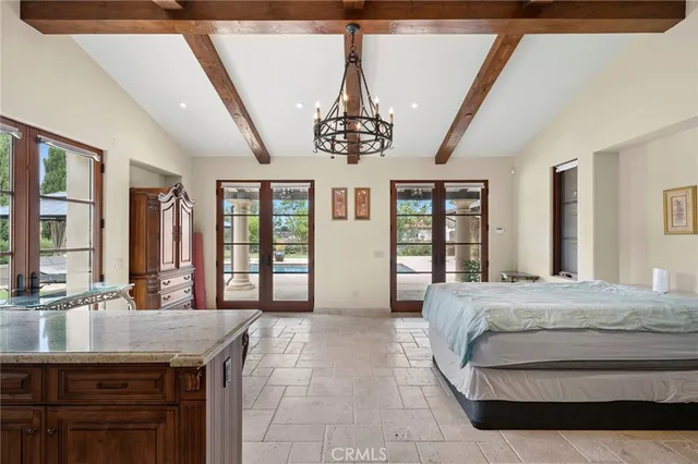 a spacious bedroom with a large bed and a chandelier