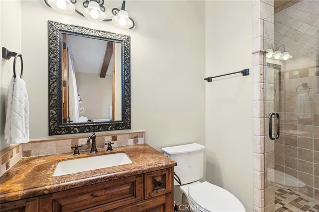 a bathroom with a granite countertop toilet sink and mirror