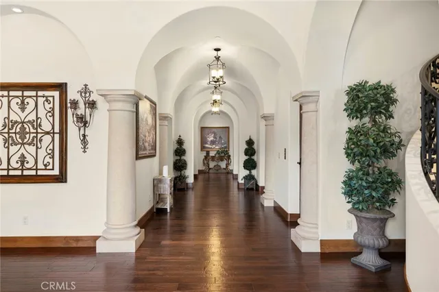 a view of a hallway with wooden floor windows and a chandelier