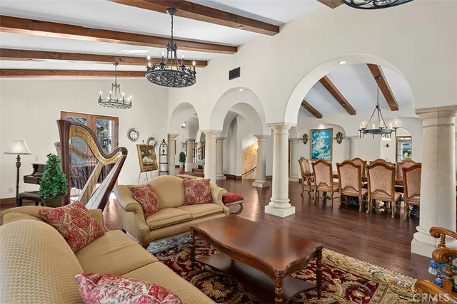 a living room with furniture a chandelier and pool table