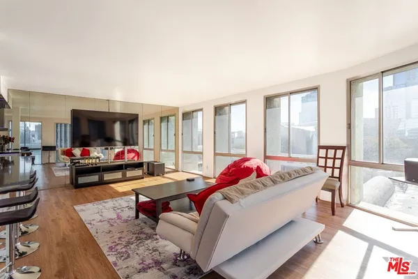 a living room with furniture and floor to ceiling windows