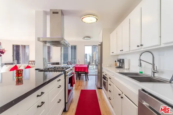 a kitchen with stainless steel appliances granite countertop a sink dishwasher and cabinets with wooden floor