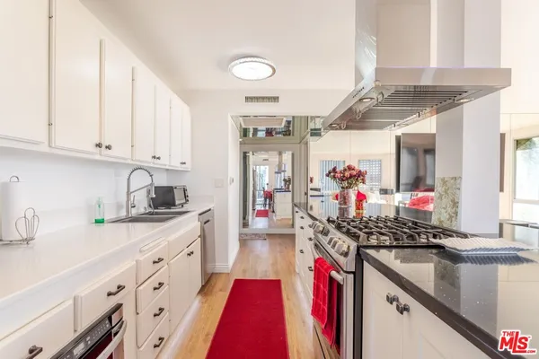a open kitchen with granite countertop a sink a stove and cabinets
