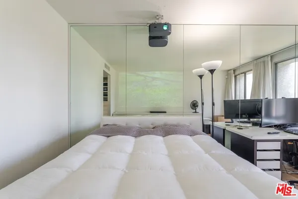 a bedroom with a bed and a mirror