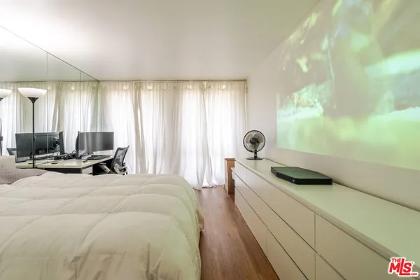 a spacious bedroom with a bed and a chandelier