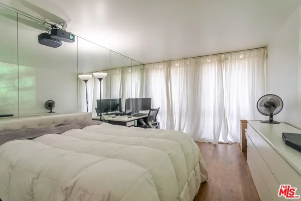 a room with stainless steel appliances granite countertop a refrigerator and a wooden floor