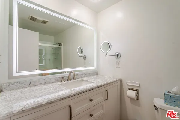 a bathroom with a sink mirror vanity and toilet