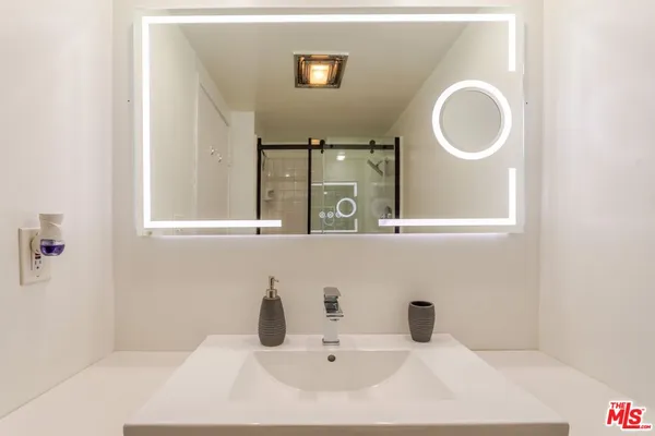 a bathroom with a granite countertop sink and a mirror