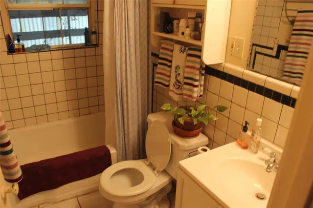 a bathroom with a sink a toilet and shower curtain