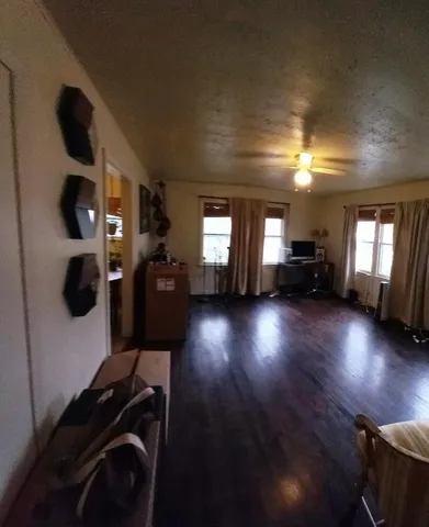 a view of a livingroom with furniture wooden floor and windows