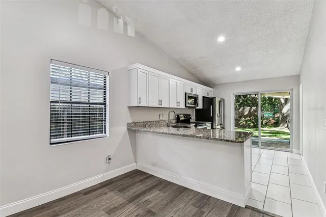 a kitchen with stainless steel appliances granite countertop a stove a sink and a microwave