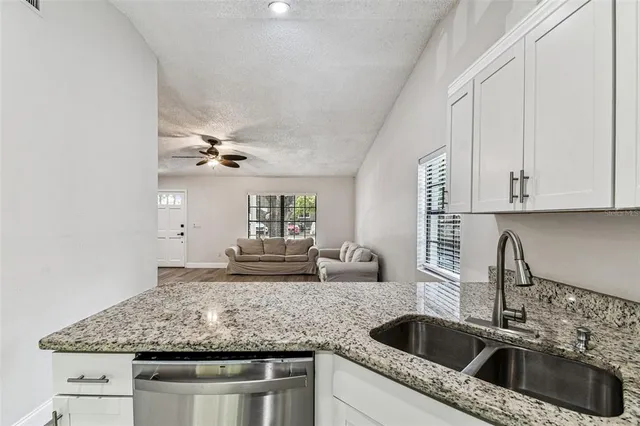 a kitchen with granite countertop a sink and a refrigerator
