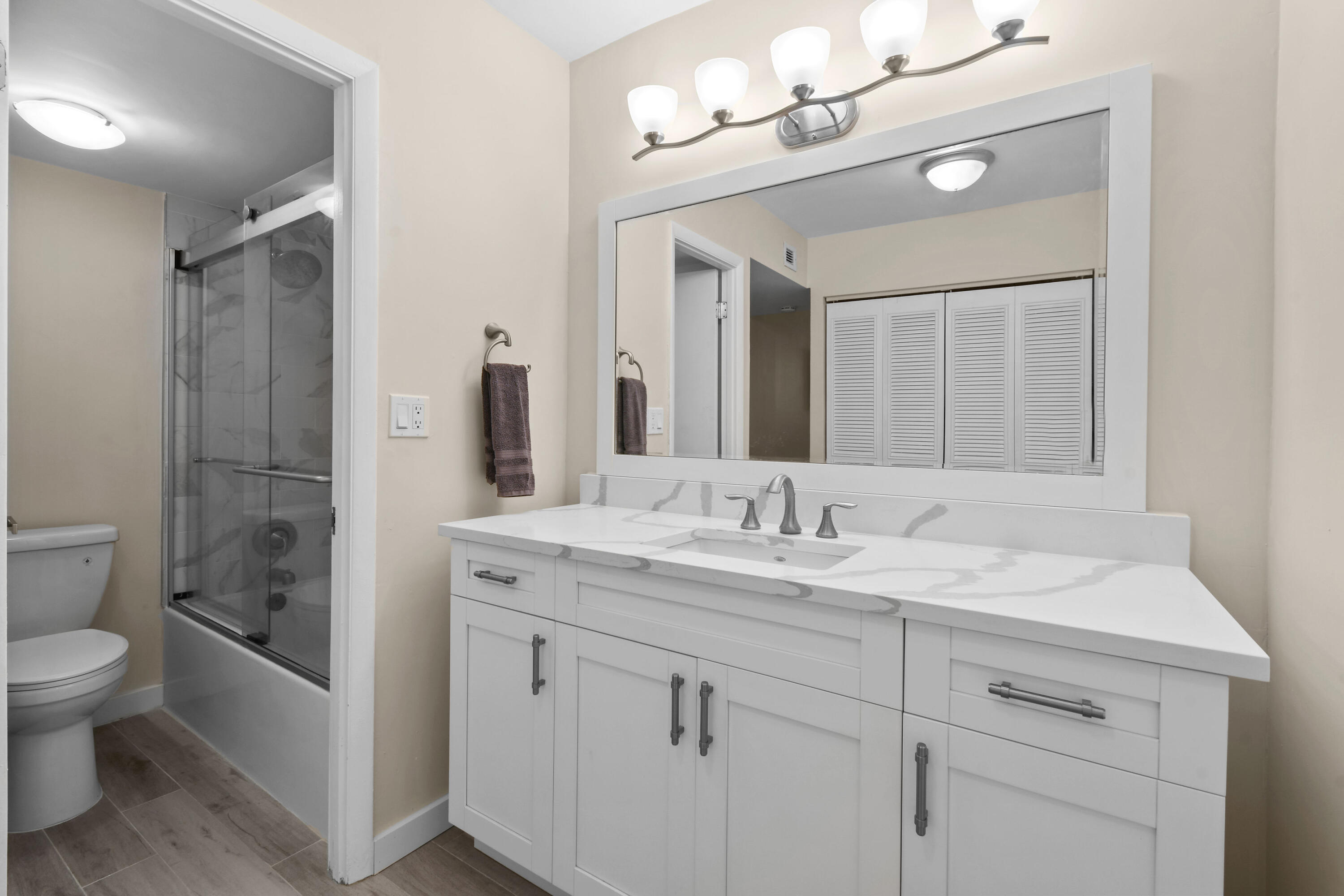 3540 South Ocean Boulevard, Unit 611 South Palm Beach, FL 33480 - Photo 12 of 27 a bathroom with a granite countertop sink a toilet and a mirror